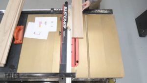 man running ash wood board through Harvey Alpha table saw