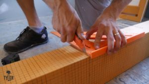 man cutting Schluter prefabricated shower curb