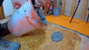 man applying mortar to plywood board for underlayment