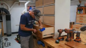 man affixing screws to drawer front handle